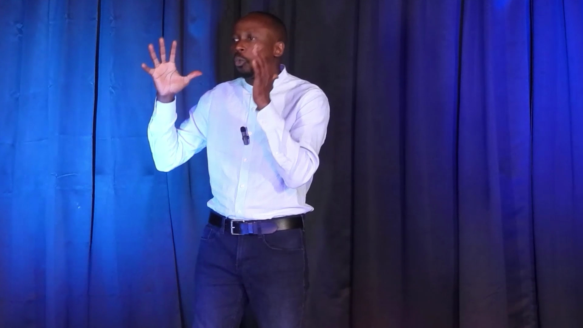 Amas on stage in white shirt and jeans close-up